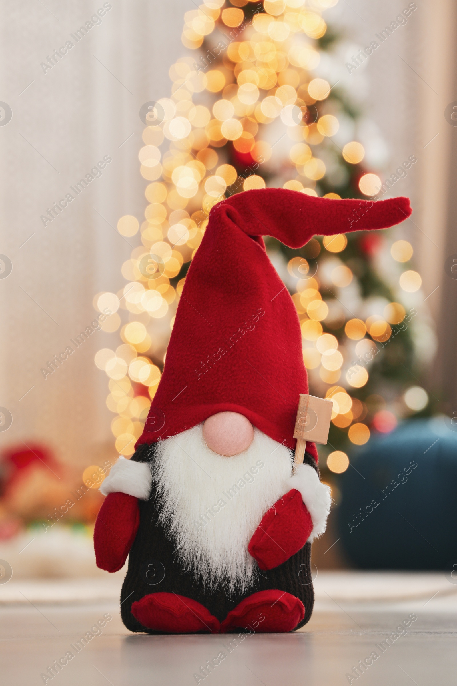 Photo of Cute Christmas gnome on floor in decorated room
