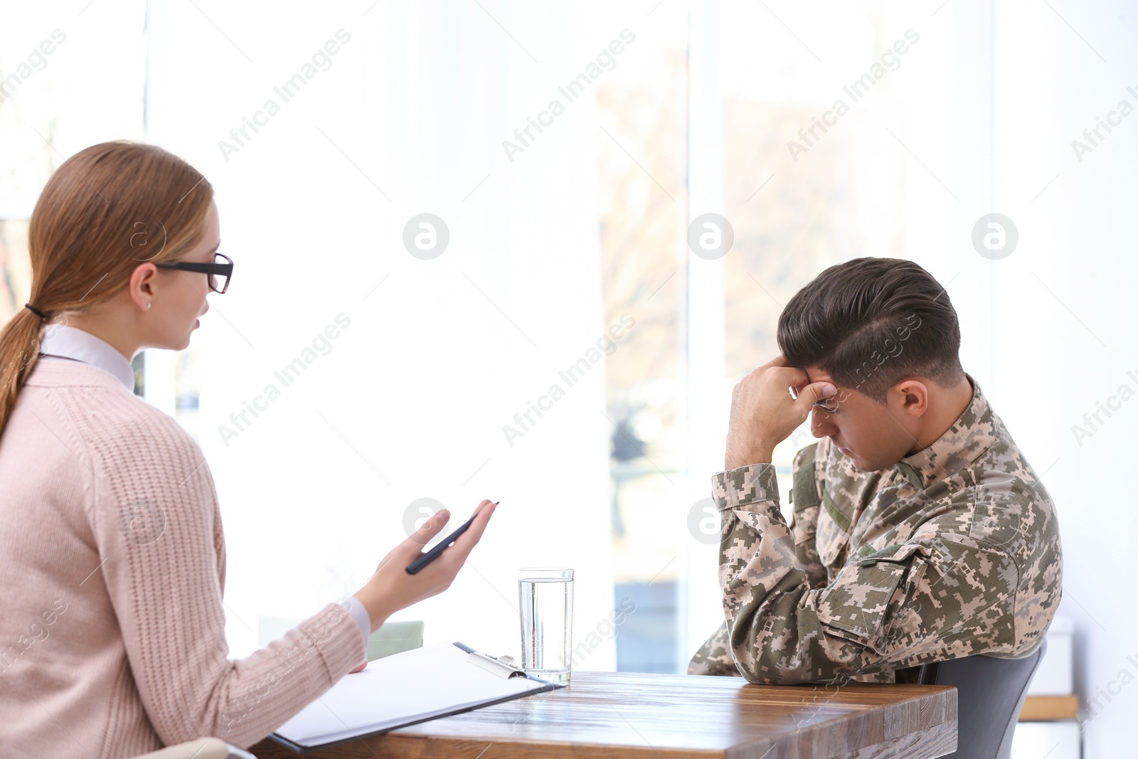 Photo of Psychotherapist working with military officer in office