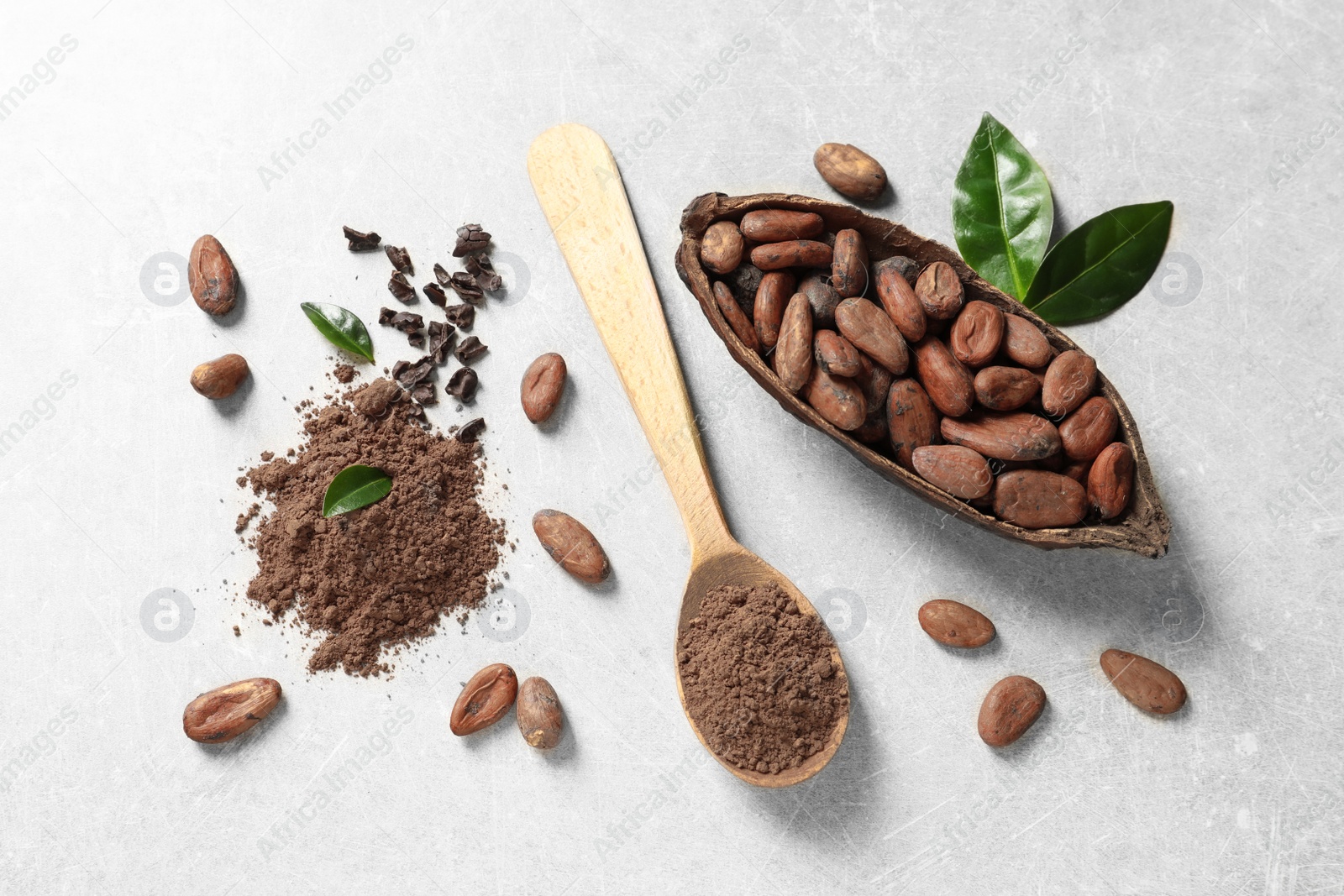 Photo of Flat lay composition with cocoa pod, beans and powder on light table