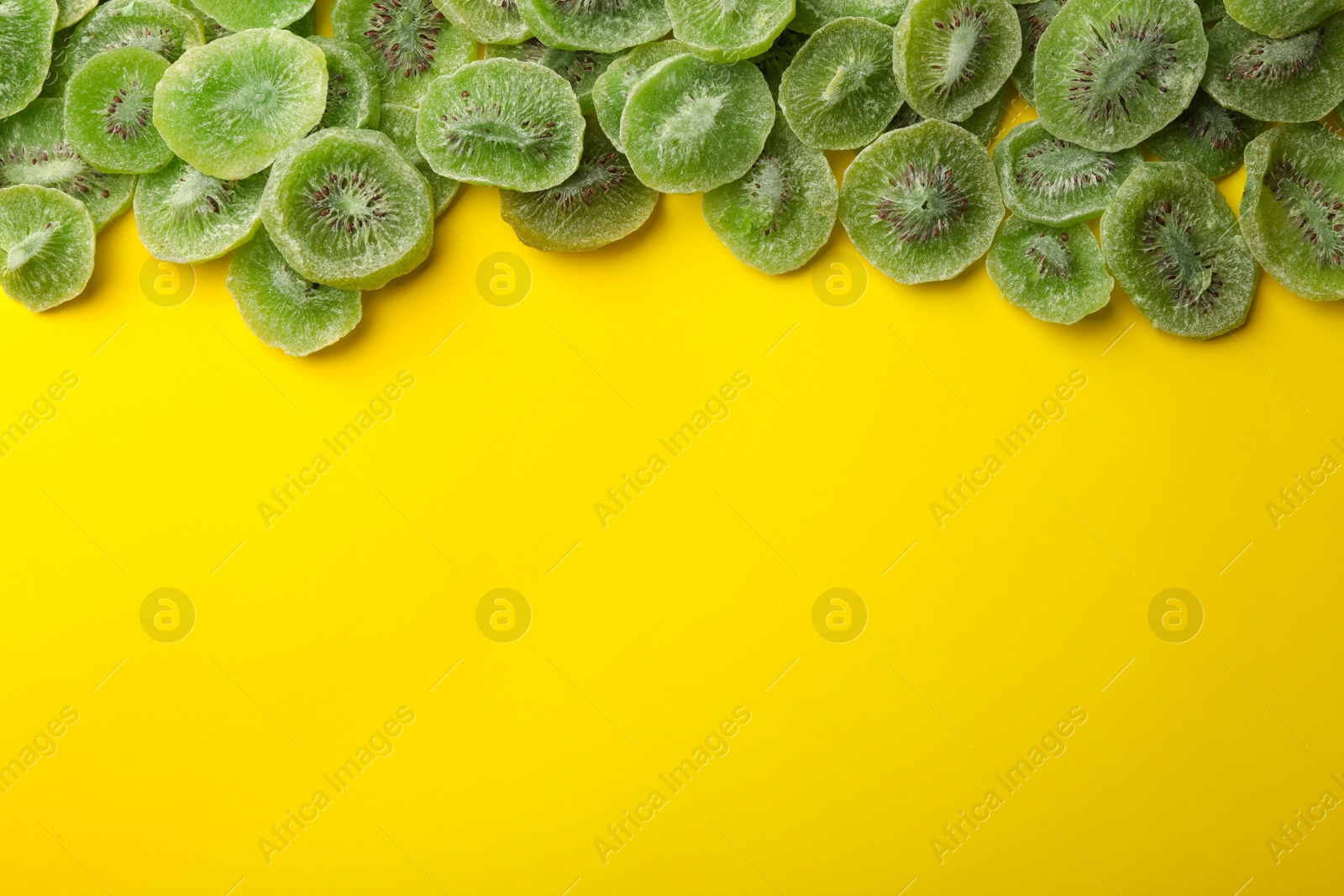 Photo of Slices of kiwi on color background, top view with space for text. Dried fruit as healthy food