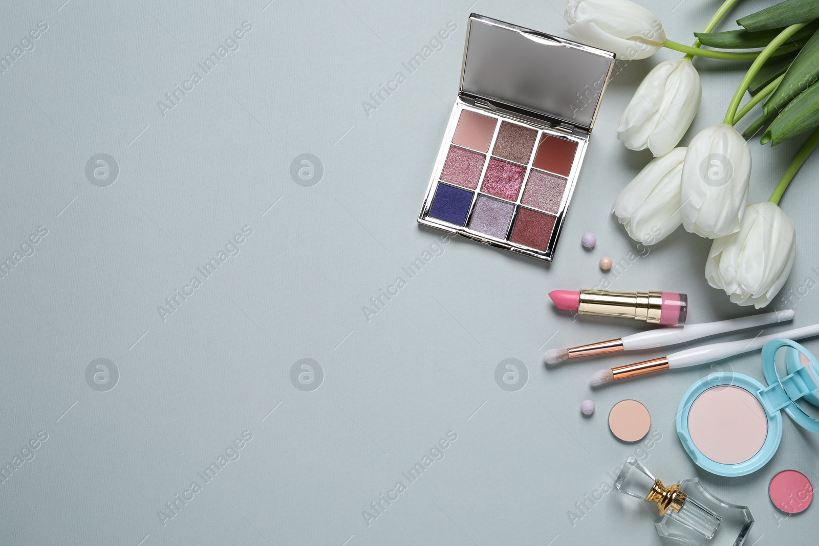 Photo of Flat lay composition with makeup products and beautiful tulips on light grey background. Space for text