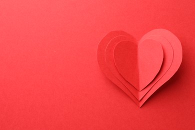 Photo of Paper hearts on red background, top view. Space for text