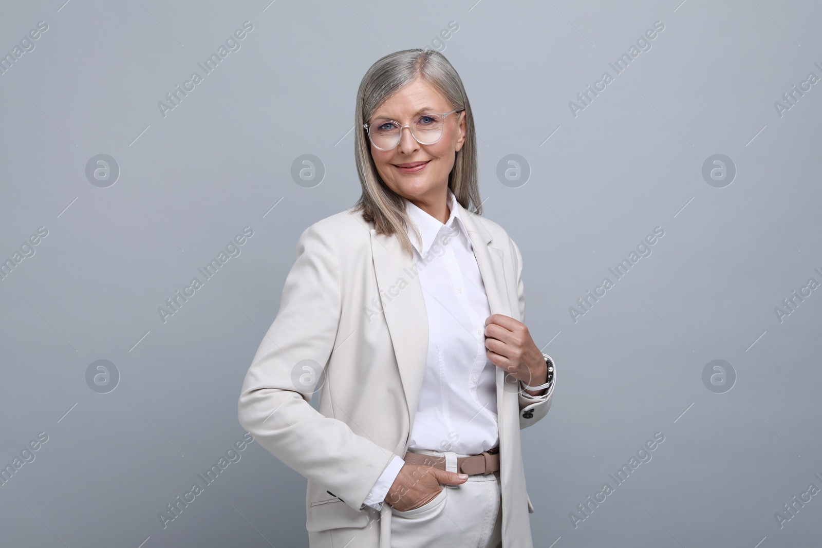 Photo of Portrait of beautiful senior woman in glasses on grey background