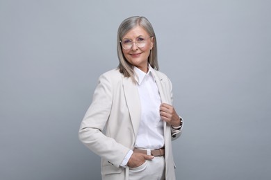 Photo of Portrait of beautiful senior woman in glasses on grey background