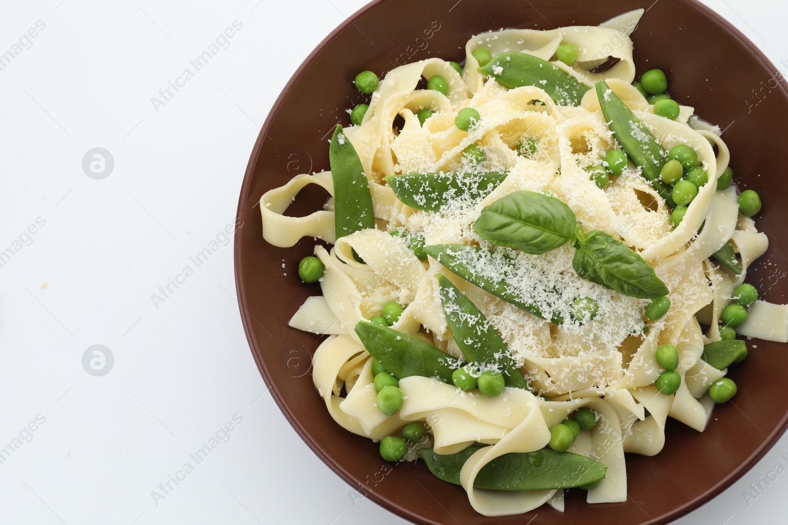 Photo of Delicious pasta with green peas isolated on white, top view