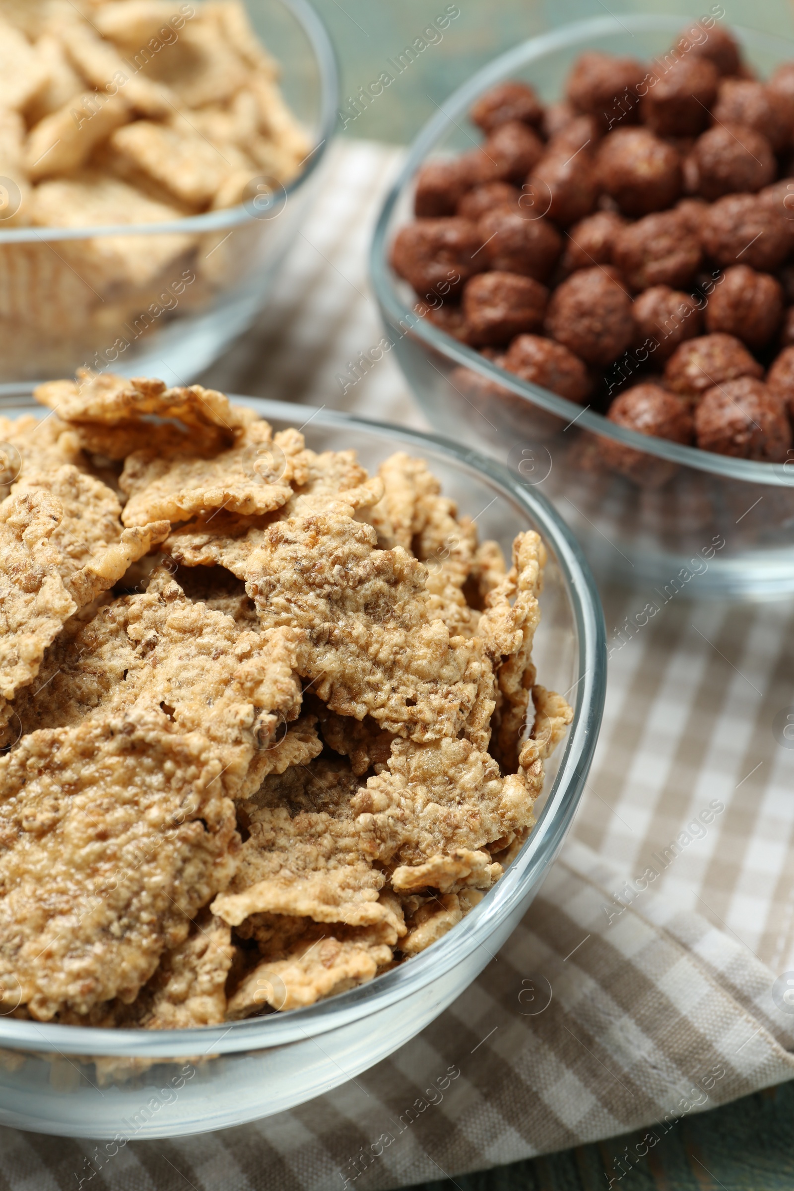 Photo of Different delicious breakfast cereals on kitchen towel, closeup