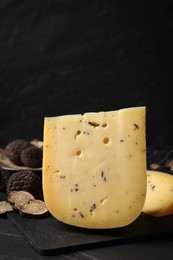 Photo of Fresh cheese and truffles on black table