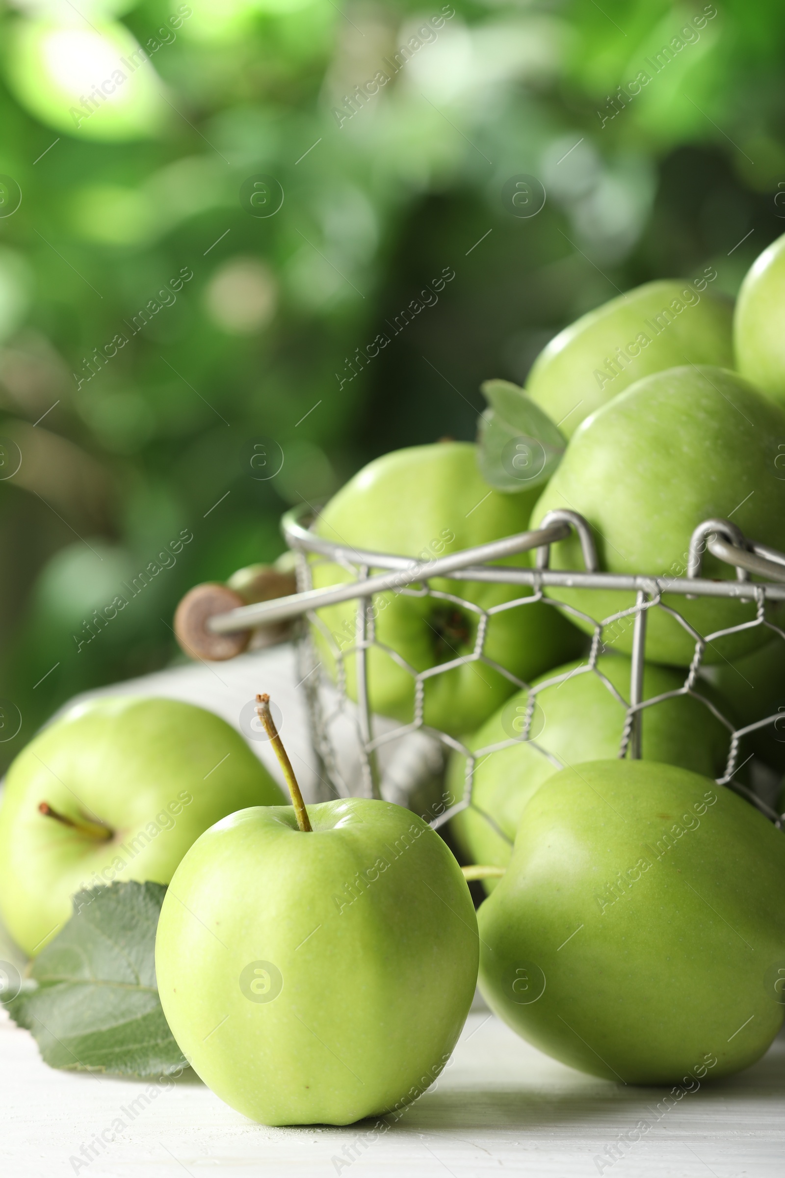 Photo of Ripe green apples on white table outdoors