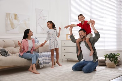 Photo of Happy family with children having fun in living room. Adoption concept