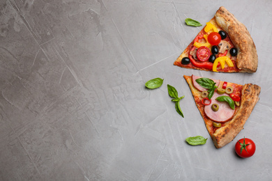 Slices of different delicious pizzas on grey table, flat lay. Space for text
