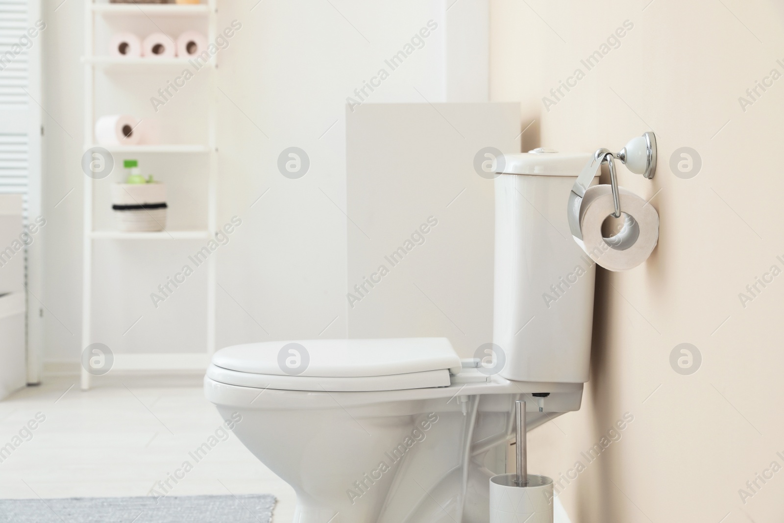 Photo of Holder with toilet paper roll on wall in bathroom