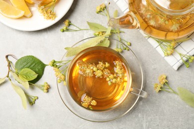 Photo of Flat lay composition with tasty tea and linden blossom on light grey table