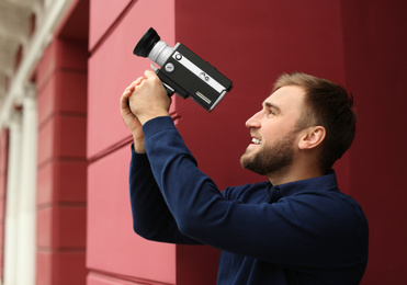 Photo of Young man with vintage video camera outdoors