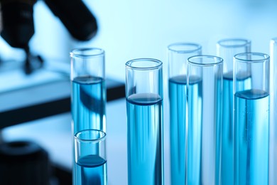 Photo of Test tubes with light blue liquid in laboratory, closeup