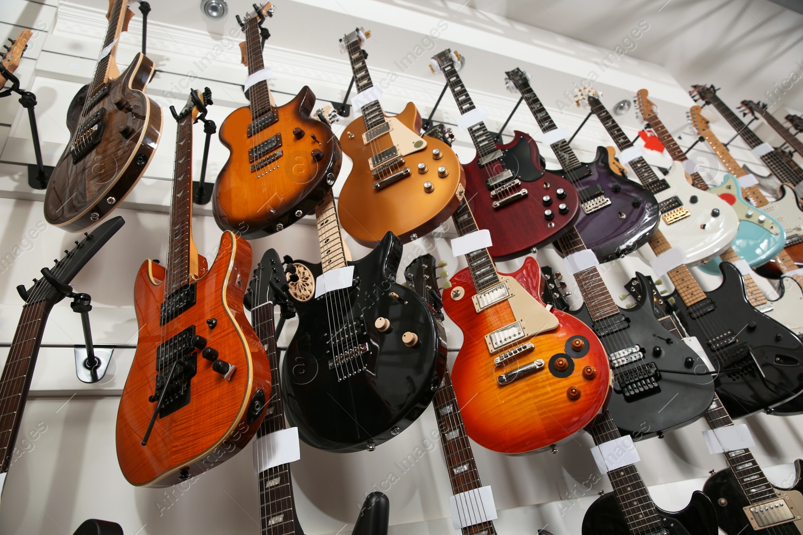 Photo of Rows of different guitars in music store, low angle view