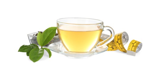 Photo of Glass cup of diet herbal tea, measuring tape, dry and fresh leaves on white background