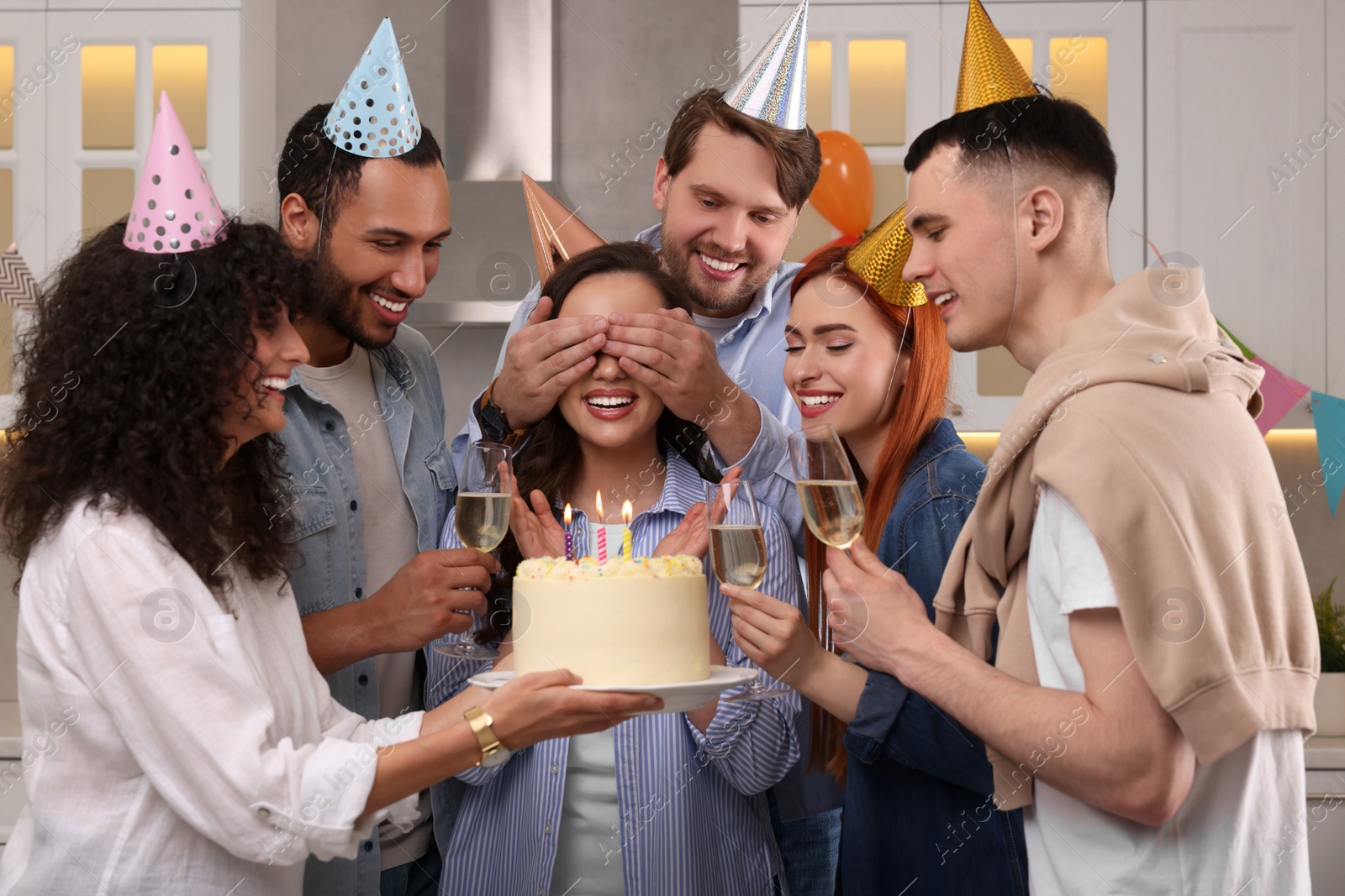 Photo of Happy friends with tasty cake celebrating birthday indoors