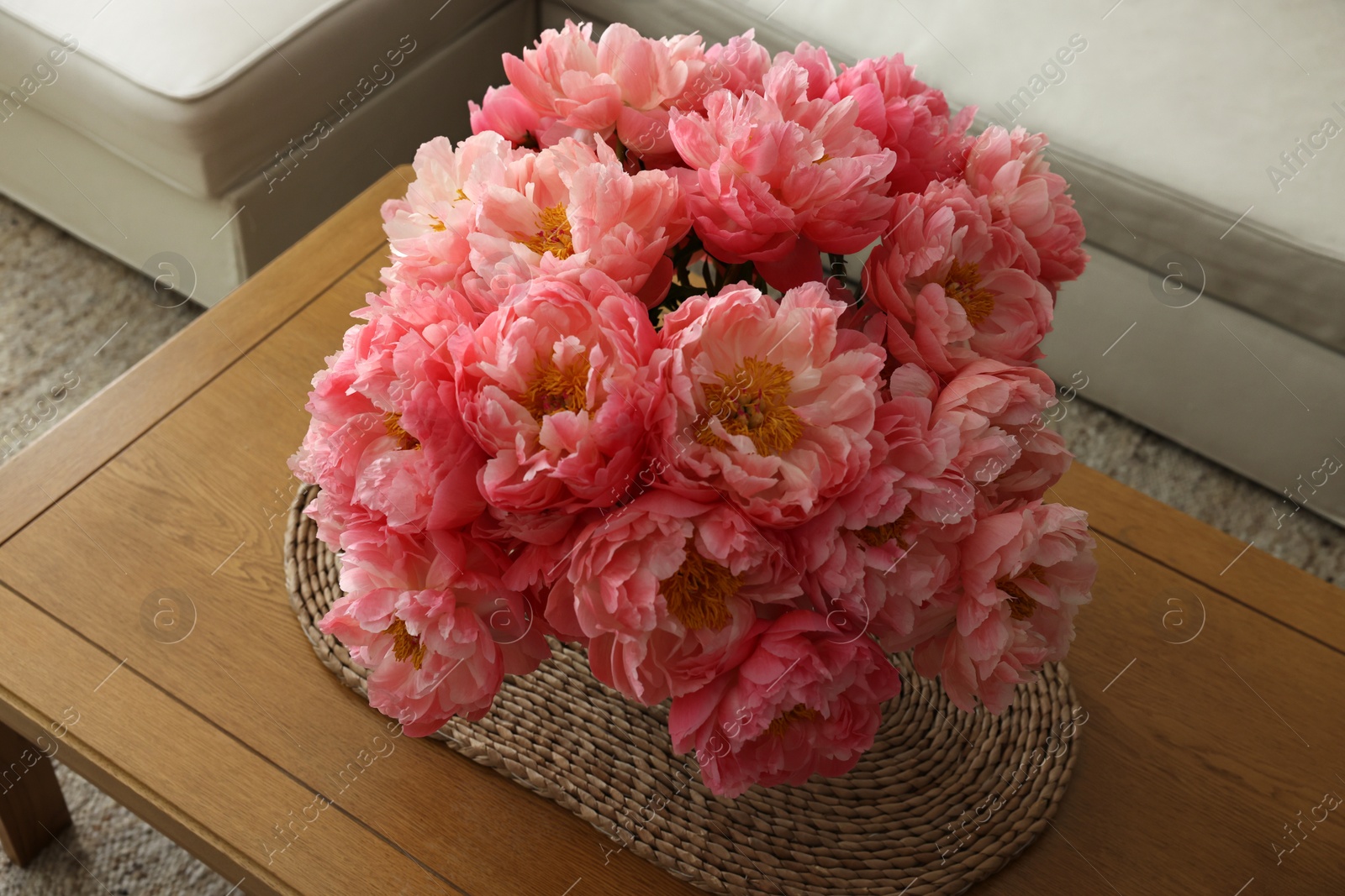 Photo of Beautiful pink peonies in vase on table indoors, above view