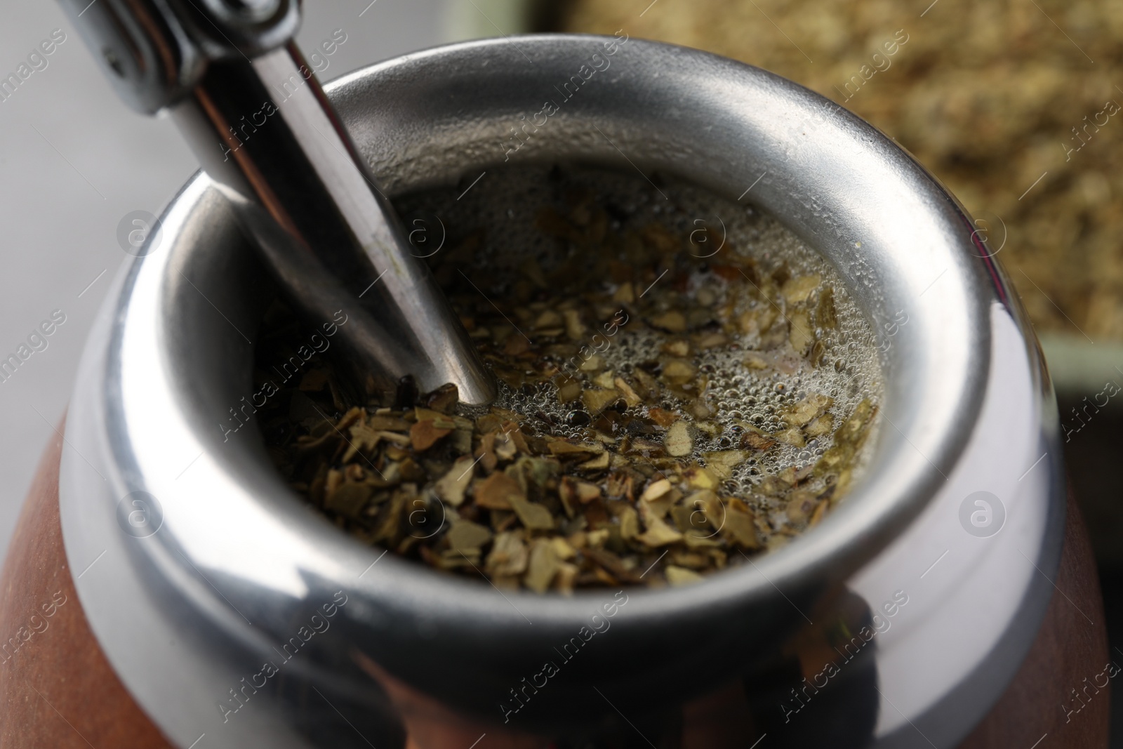 Photo of Calabash with bombilla and mate tea on table, closeup