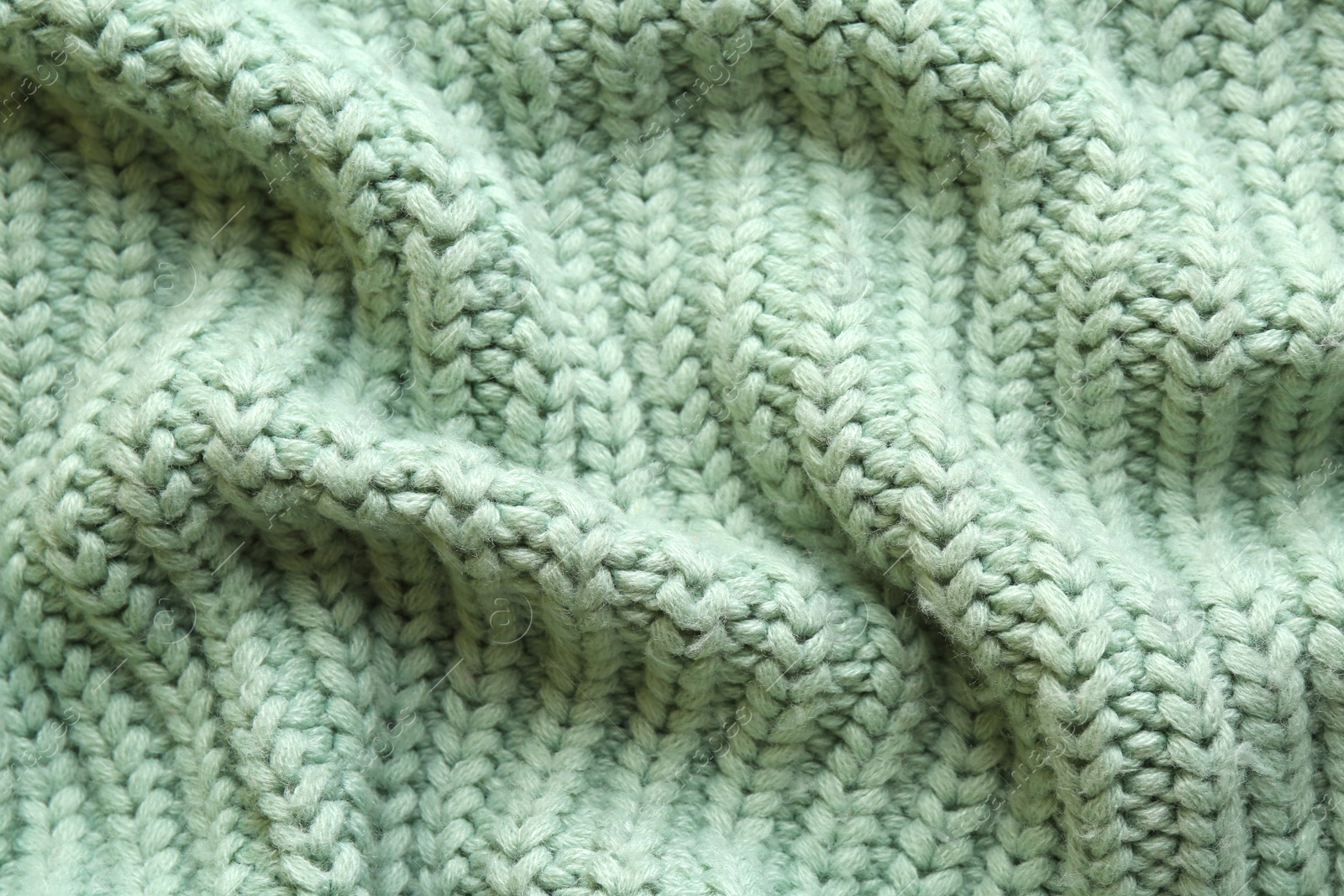 Photo of Beautiful pale green knitted fabric as background, top view