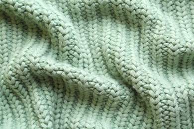 Beautiful pale green knitted fabric as background, top view