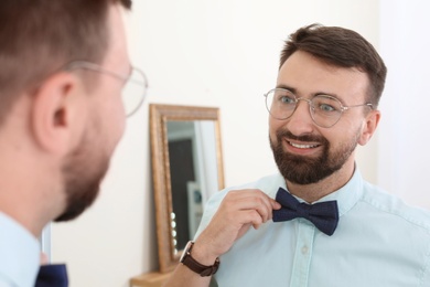 Young handsome man near mirror in makeup room