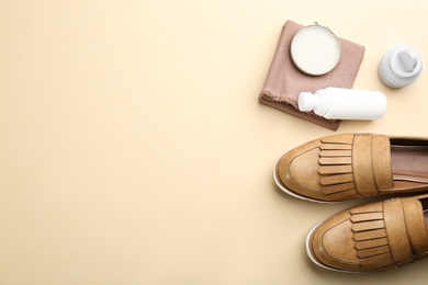 Photo of Flat lay composition with shoe care accessories and footwear on beige background. Space for text