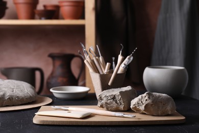 Clay and set of modeling tools on table in workshop