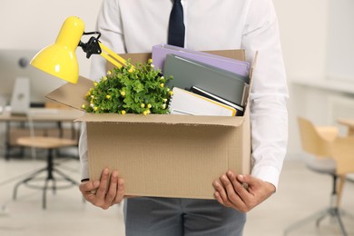 Unemployment problem. Man with box of personal belongings in office, closeup