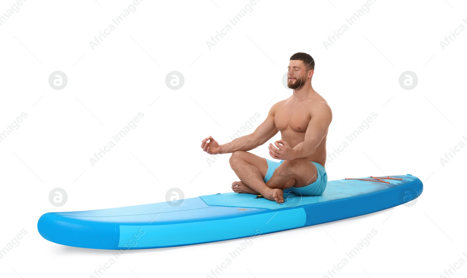 Photo of Handsome man practicing yoga on blue SUP board against white background