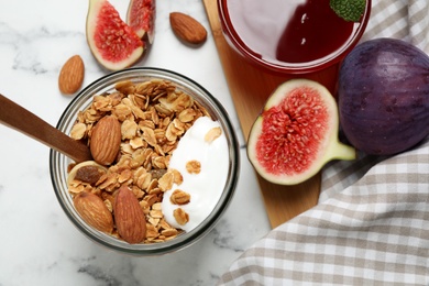 Tasty homemade granola with yogurt on white marble table, flat lay. Healthy breakfast