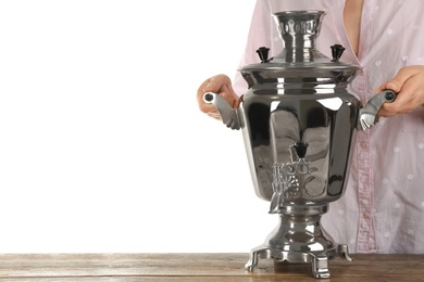 Photo of Woman holding traditional Russian samovar on wooden table against white background, closeup. Space for text