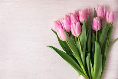 Photo of Beautiful pink spring tulips on white wooden background, top view. Space for text