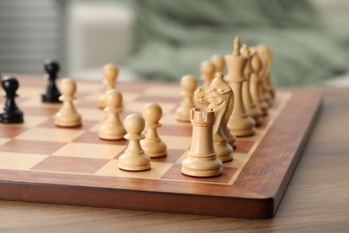 Photo of Chess board with white pieces on wooden table, closeup