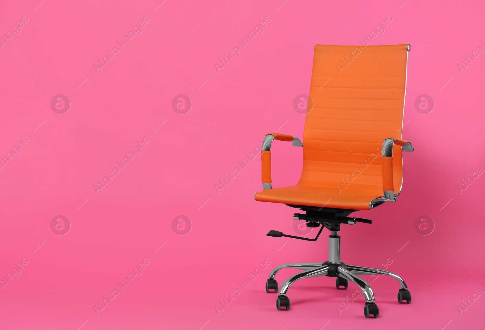 Photo of Comfortable office chair on pink background, space for text