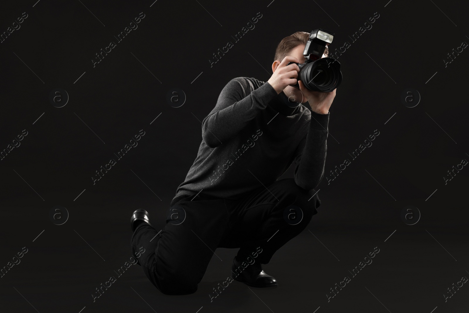 Photo of Professional photographer taking picture on black background