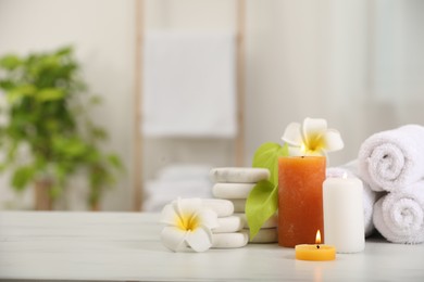 Photo of Composition with different spa products and plumeria flowers on white marble table indoors, space for text