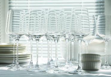 Set of empty wine glasses and dishware on table indoors