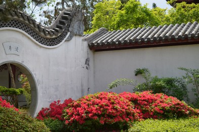 HAREN, NETHERLANDS - MAY 23, 2022: Beautiful view of blooming bushes and Moon gate in Chinese garden