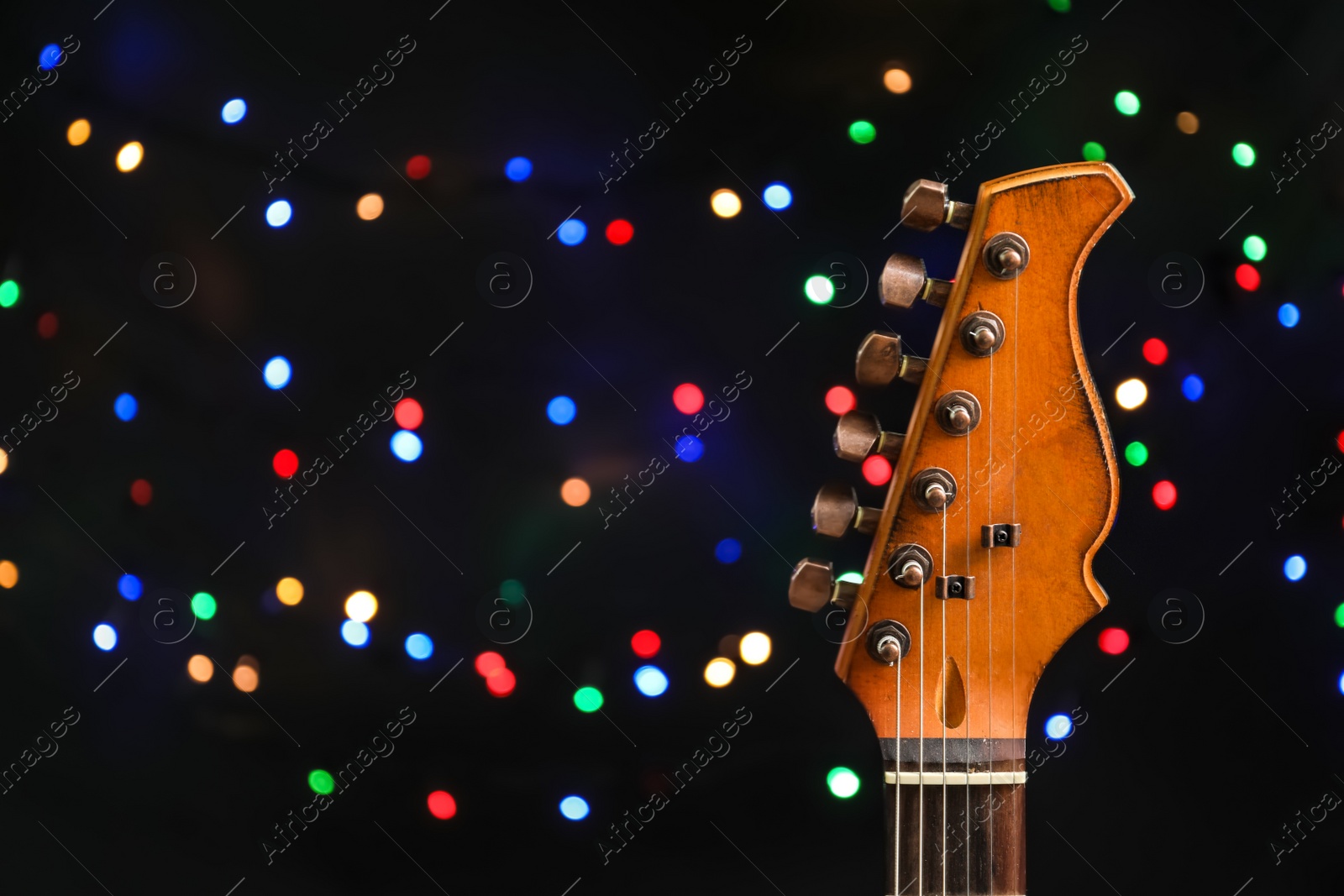 Photo of Guitar against blurred lights. Christmas music concept