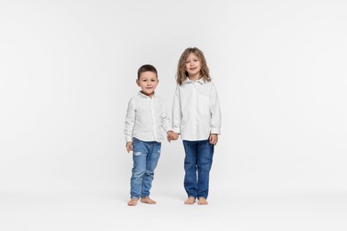 Photo of Cute little children on white background. Happy family