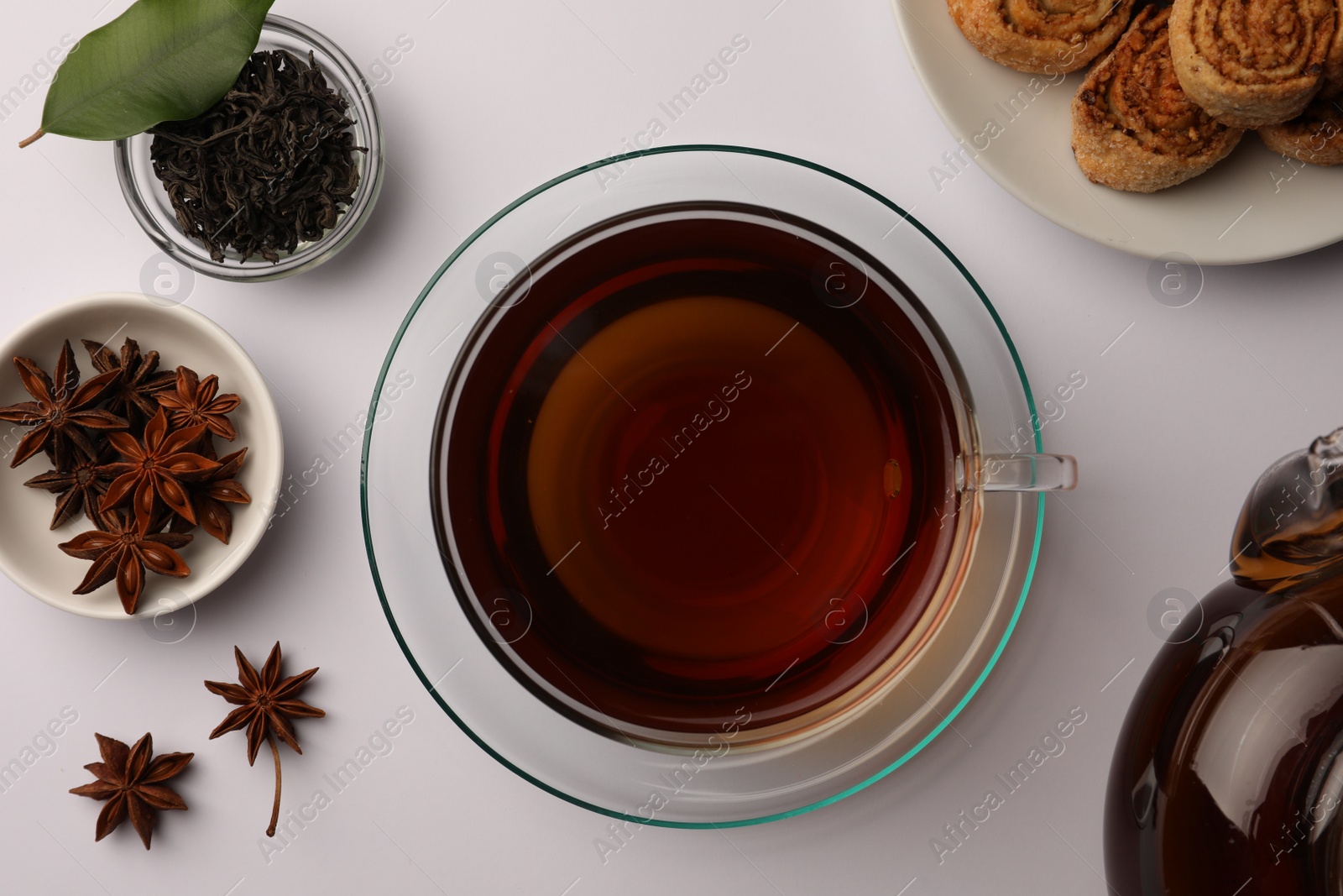 Photo of Flat lay composition with aromatic tea, cookies and anise stars on white table