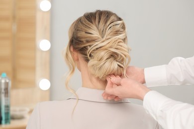 Hair styling. Professional hairdresser working with client indoors, closeup