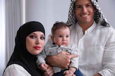 Photo of Happy Muslim family with little son indoors