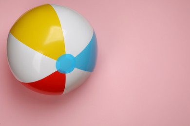 Photo of Colorful beach ball on pink background, top view. Space for text