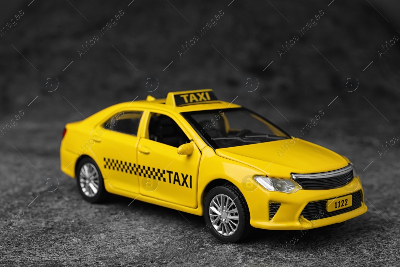 Photo of Yellow taxi car model on grey background