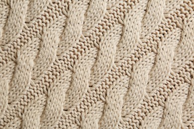 Photo of Beige knitted fabric with beautiful pattern as background, top view