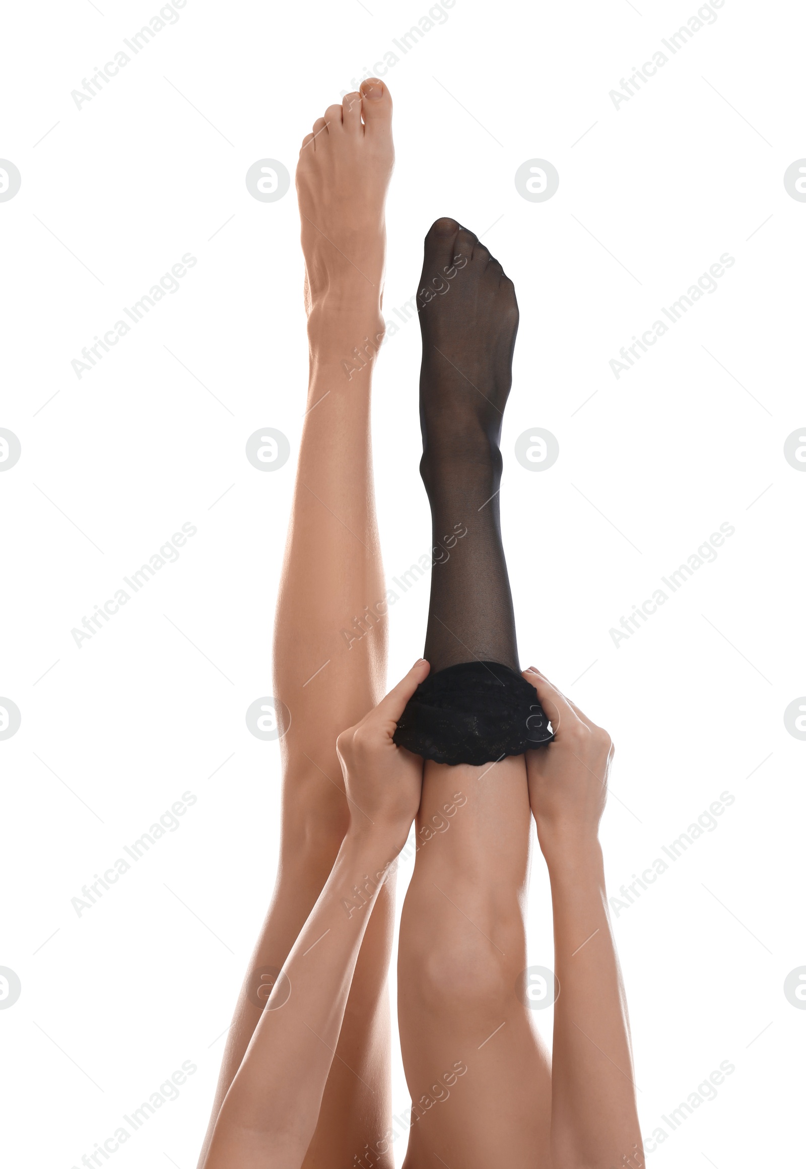 Photo of Young woman putting on stocking against white background, closeup