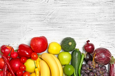 Rainbow composition with fresh vegetables and fruits on wooden background, flat lay