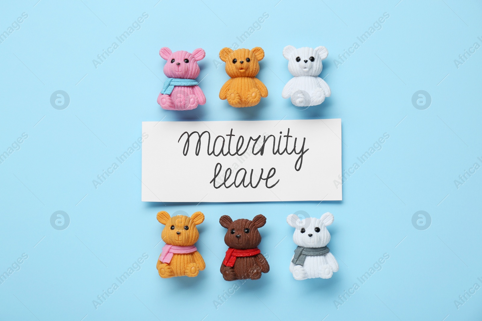 Photo of Card with phrase Maternity Leave and toys on light blue background, flat lay